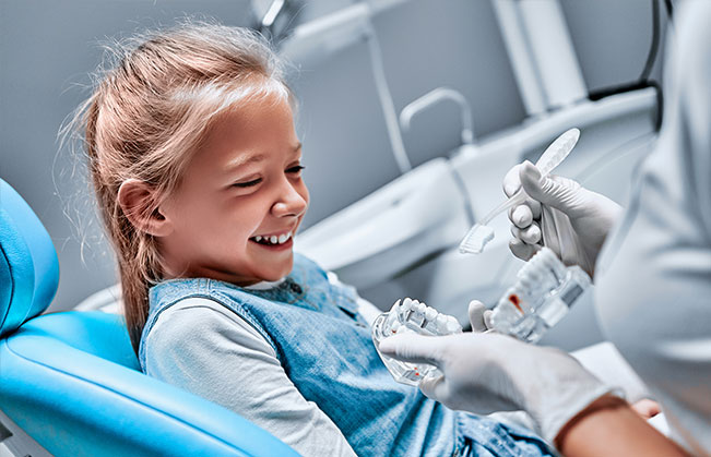 Dentist talking to young dental patient
