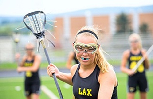 Teen playing lacrosse with an athletic mouthguard in place