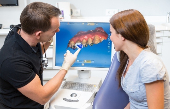 Dentist and dental patient looking at CEREC dental restoration design software