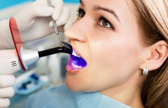 Woman receiving dental exam after cosmetic dental bonding