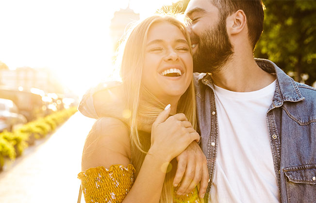 Man and woman with healthy smiles after dental crown restoration