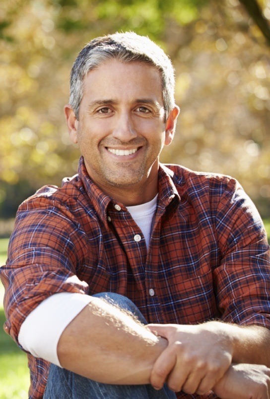 Man smiling after tooth replacement with dental implants