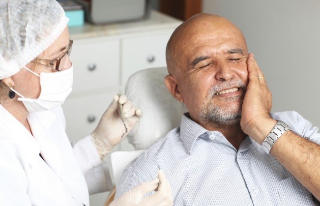 Man holding jaw in pain before emergency dentistry