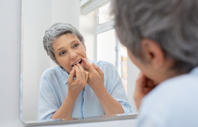 Woman flossing teeth to prevent dental emergencies