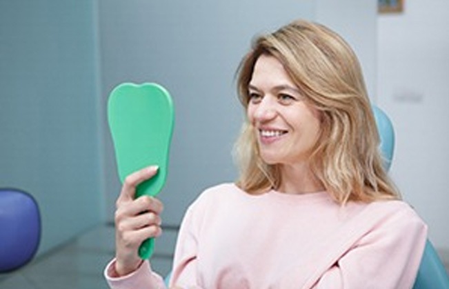 Woman looking at smile in mirror