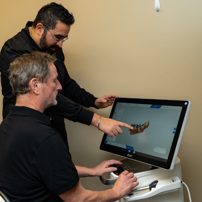 Dentist and dental patient looking at digital impressions