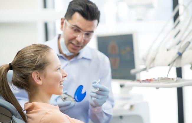 Dentist explaining how Invisalign treatment works to dental patient