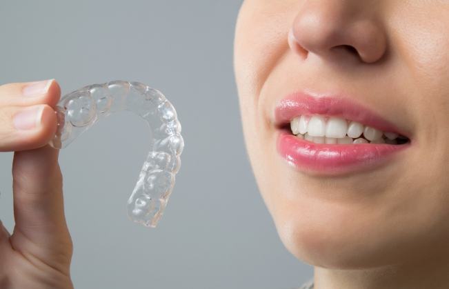 Closeup of patient holding an Invisalign tray