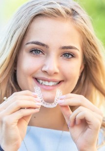 young woman holding clear aligner