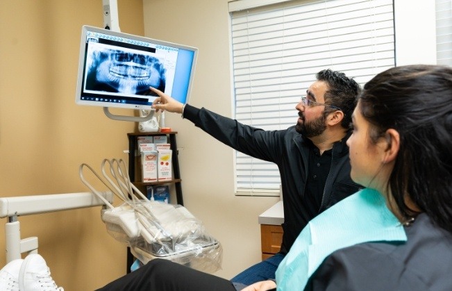 Doctor Dhaliwal and dental patient looking at digital x-rays