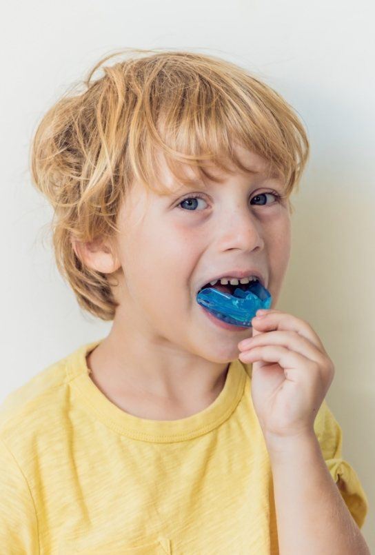 Child placing a mouthguard