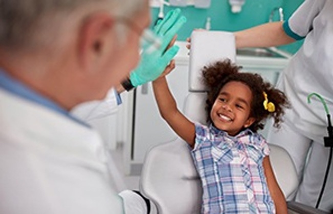 Child giving dentist a high five