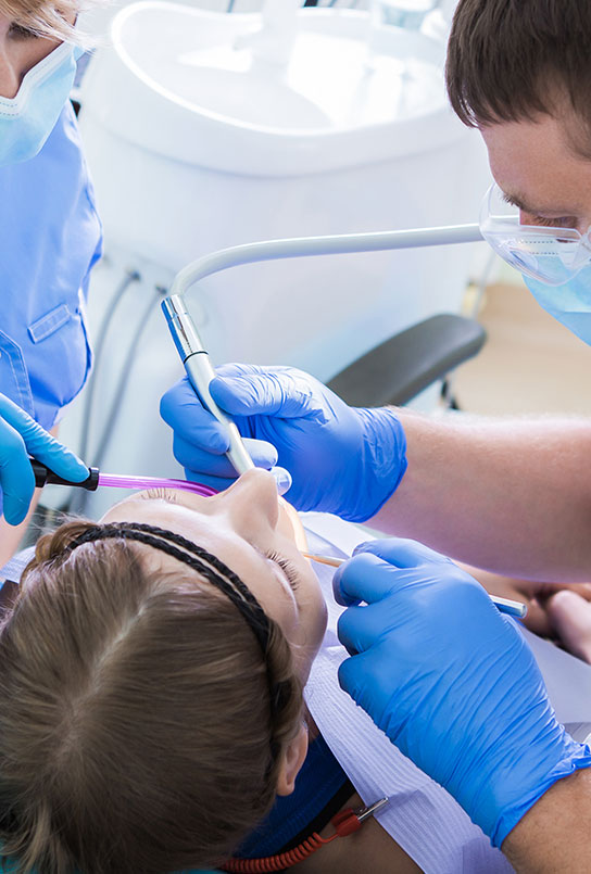 Dentist performing oral surgery