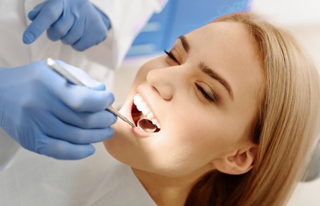 Woman receiving dental checkup and teeth cleaning