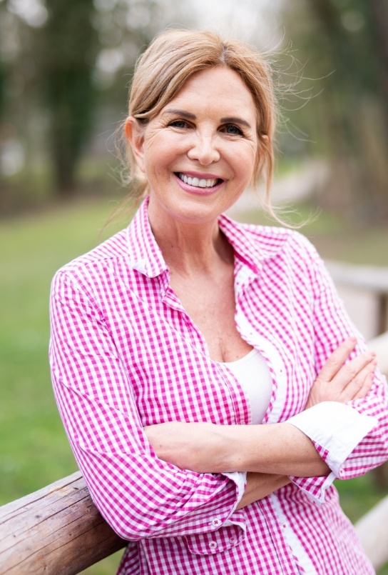 Woman smiling after replacing missing teeth