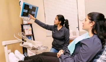 Dentist talking to dental patient during preventive dentistry visit