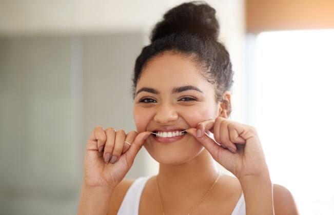 Woman flossing after wisdom tooth extraction