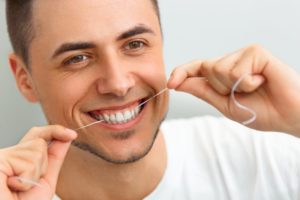 a man flossing his teeth