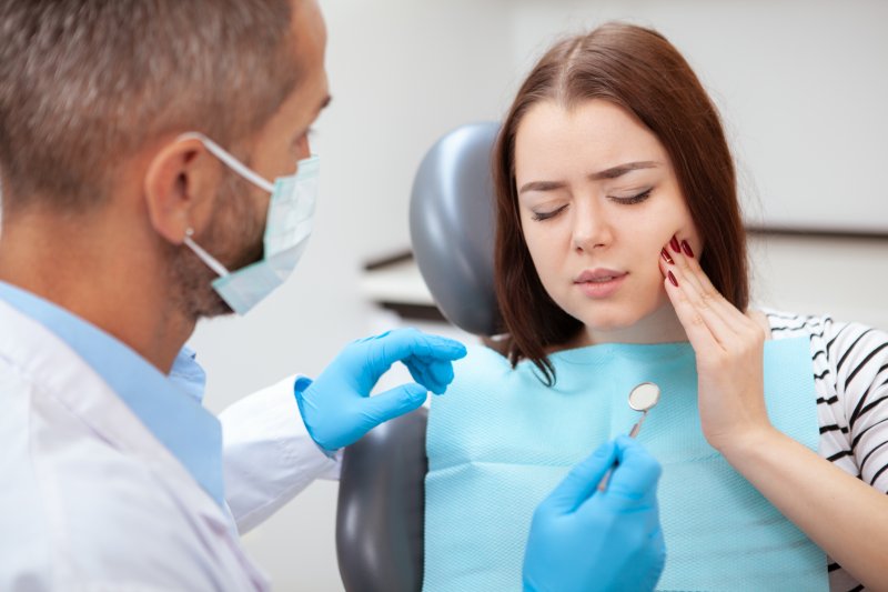 Red-haired female patient visiting emergency dentist for toothache