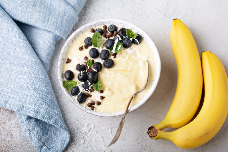 Bowl of cold soup next to some bananas