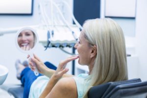 mature woman dental chair smile in mirror