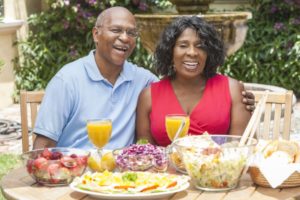 couple sitting at a table of food after recovering from All-on-4 surgery