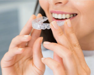 Woman holding Invisalign aligner