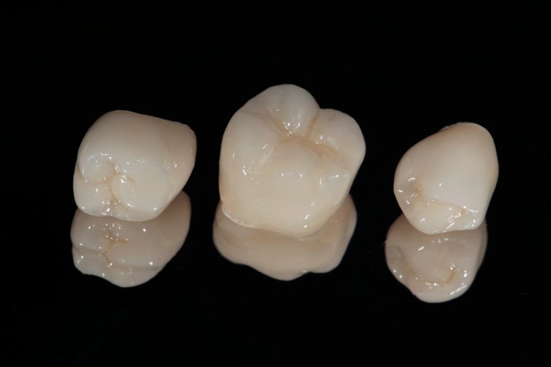 A close-up of dental crowns on a black background