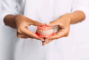 Dentist holding a brand new set of dentures