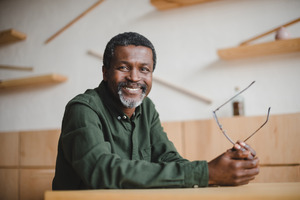 Senior man smiling and holding glasses